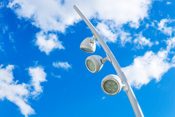 A modern street LED light lamp against the blue sky with clouds.