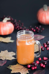 Halloween cocktail, pumpkin orange drink with spices. Dark vintage dirty background. Creative atmospheric decoration