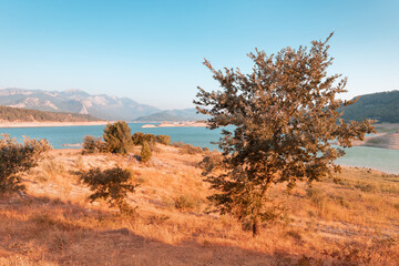 Fototapeta na wymiar Karacaoren is a dam pond on the Aksu river in Turkey near the city of Antalya. A popular place for recreation and fishing. Panoramic view of the lake and the Taurus mountains at sunset