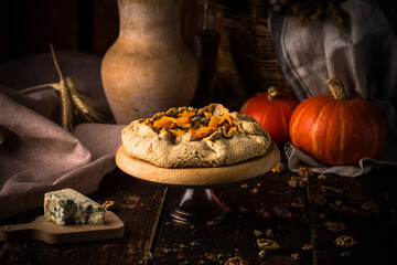 Pumpkin pie with blue cheese at wooden table.