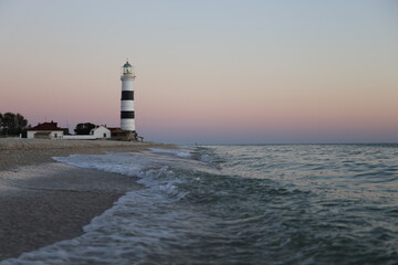 lighthouse with black and white stripes on the seashore, Tendrovskaya Spit, Ukraine