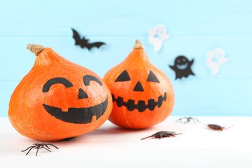 pumpkins with painted faces on a colored background for Halloween.
