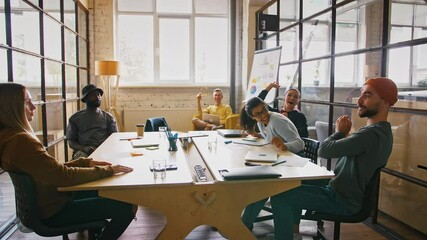 Young business team throwing tennis ball to each other, having fun during meeting at office