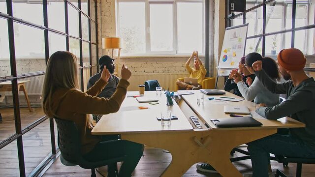 Middle aged boss caught tennis ball during his business team game, workers cheering for him
