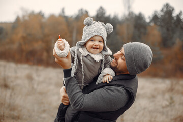 Family in a autumn park. Fathre in a black jacket. Cute little girl