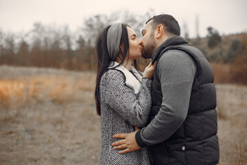 Cute couple in a field. Man in a black jacket.