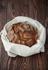 circle bread in a linen cloth on a wooden background