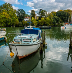 Fototapeta premium A view past boats moored on the River Test at Eling near Southampton, UK in Autumn