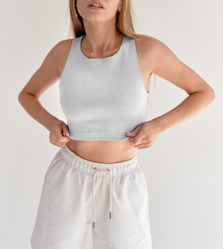 girl wears white crop top and white shorts. studio shooting of young woman in casual street wear