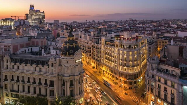 Time lapse view of sunset over historical buildings and traffic on Gran Via street in Madrid, the capital and largest city in Spain.