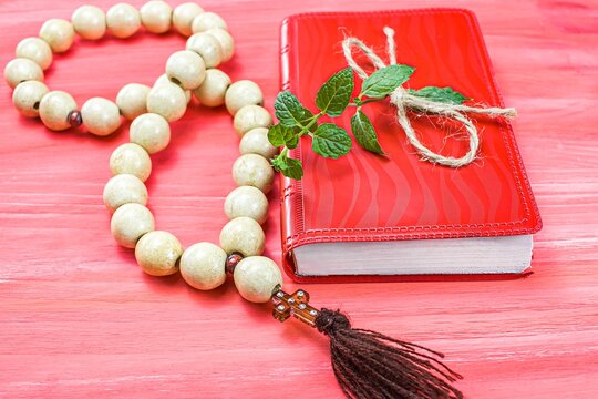 Red little prayer book on a wooden table ,  background of religion