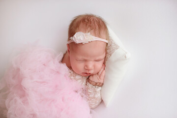 newborn photoshoot of a small newborn baby sleeps on his tummy, propping his cheek with his palm, a photo session of a newborn little baby