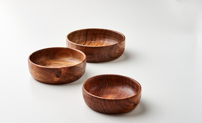 Tres tazones hondos de madera de acacia sobre fondo blanco