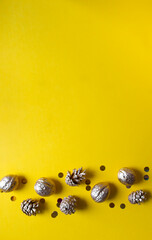 there is a place for text on a yellow gold background and on the edge there are golden nuts, golden cones and golden candy. christmas tree decorations gold