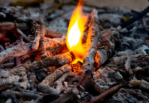Hot coals and little flames in a dying fire