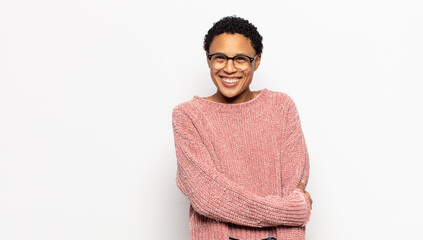 young afro woman laughing shyly and cheerfully, with a friendly and positive but insecure attitude