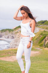 Young caucasian girl with white shirt and jeans posing in a park at Saint Jean de Luz; Basque...