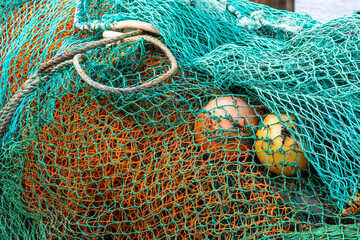 various fishing nets and floats laid on a dockside