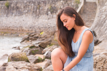 Fototapeta premium Young girl at the beach with a turquoise dress.