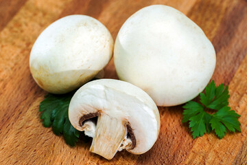 Place the sliced and whole edible, delicious porcini mushrooms and parsley on a wooden cutting Board