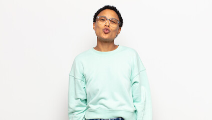 young afro woman pressing lips together with a cute, fun, happy, lovely expression, sending a kiss