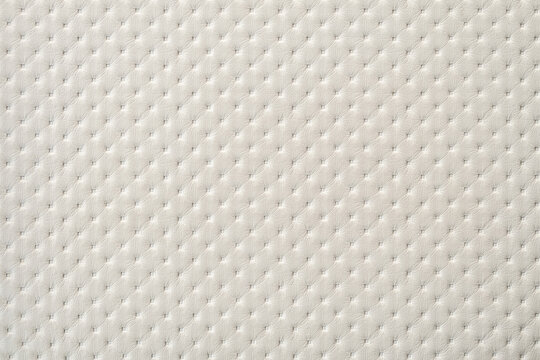 White perforated furniture upholstery leather texture. Embossing punto white sample of leatherette.