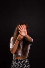 Young girl indicating to stop with a black background.