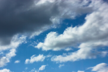 Fluffy white clouds in the blue sky in summer, reflection in the window