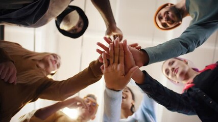 Multiethnic team putting hands together one by one, connection, teambuilding and alliance concept, below view - Powered by Adobe