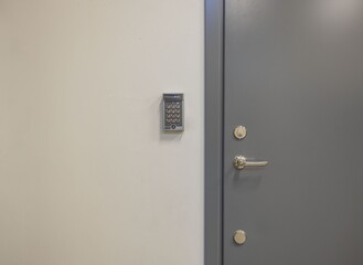 View of grey metal door with digital code lock. Security concept.