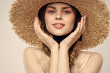 Nice girl in a straw hat with a black ribbon and in a dress on a light background romance model fun emotion