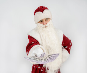 Santa Claus holds money in his hands. Isolated on light background