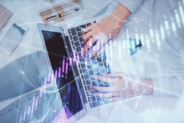 Double exposure of woman hands working on computer and forex graph hologram drawing. Top View. Financial analysis concept.