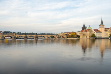
the monument of Charles Bridge from 1402 and the level of the flowing Vltava river and the light...