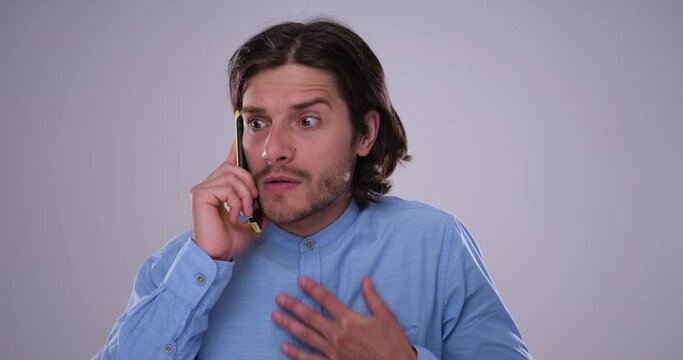 Worried man holding mobile phone away from ear while having an unpleasant conversation or listening to a complain