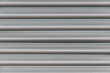 Obraz premium Close-up view of light-colored construction site fence with stripes on a city street. Fence enclosing the construction site. Forbidden entry. Stripes wall pattern