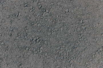Close-up top view of dark asphalt on the street. Texture grey asphalt background. Surface grunge rough asphalt. Car road, pavement, tile. Granular abstract uniform grainy surface.