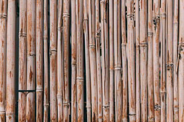 Bamboo fence background. Natural bamboo pattern. Wall texture background for interior or exterior design. Wooden texture background. Orange old grungy handicraft of bamboo weave pattern fence