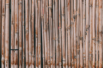 Bamboo fence background. Natural bamboo pattern. Wall texture background for interior or exterior design. Wooden texture background. Orange old grungy handicraft of bamboo weave pattern fence