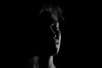 Black and white portrait of an Italian young woman on black background - obrazy, fototapety, plakaty