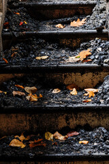 Cornwall, Ct, USA  The damaged burned steps with autumn leaves in  a wooden house damaged by fire.