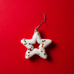 Shiny white Christmas star on red background, minimal concept