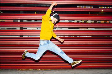 man jumping and listening music outdoor