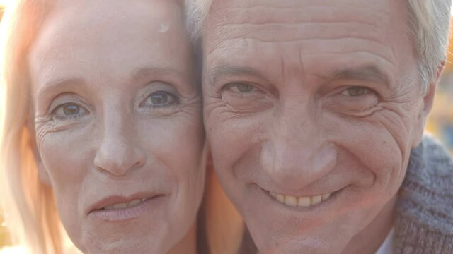 Close Up Of Face Of Happy Senior Couple Looking At Camera And Smiling Outdoors