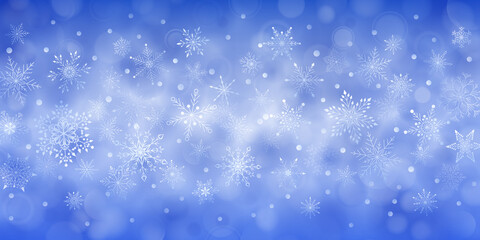 Christmas background of complex big and small falling snowflakes in blue colors with bokeh effect