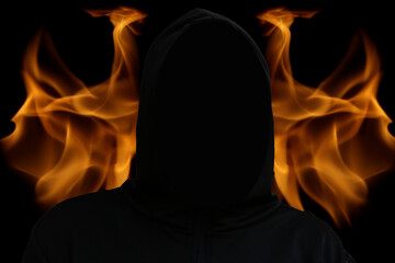 Death suit. An impersonal black robe with a hood, a symbol of death. Halloween concept. A bright glowing background with tongues of flame and fire. Selective focus