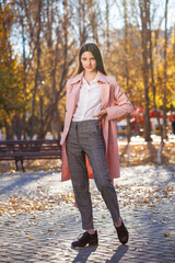  young brunette girl posing in autumn park