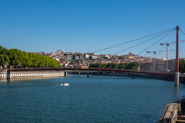 Obraz premium Vue du Rhône et d'un pont de la ville de Lyon avec les rives et les quartiers urbanisés un jour ensoleillé avec un ciel bleu sans nuage