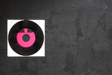 Aged black paper cover and vinyl LP record isolated on black background