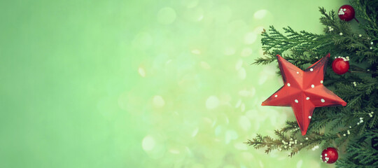 Christmas red star ornament and natural decoration on green background with copy space. Christmas, banner, background or card